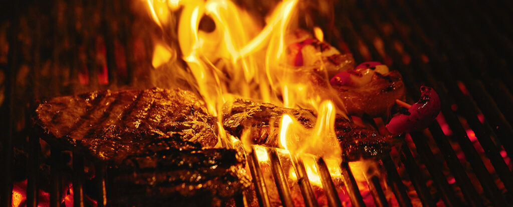 Juicy beef steak flips in a barbecue flame, life style, food photo, copy space.