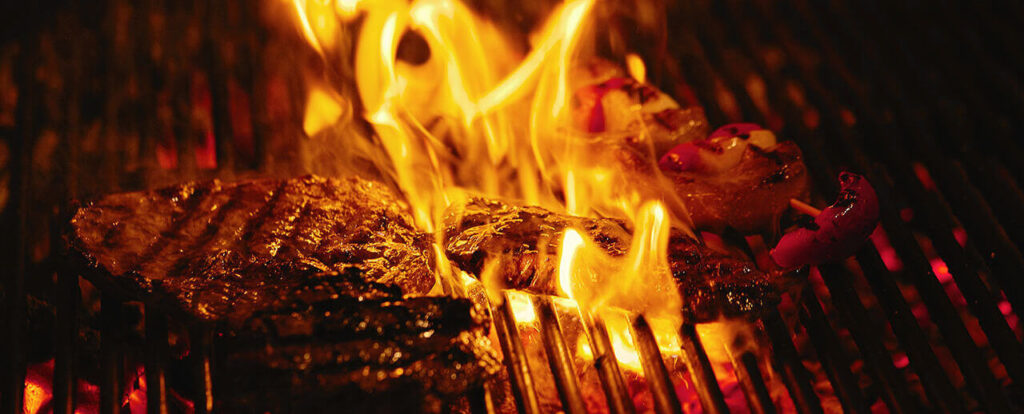 Juicy beef steak flips in a barbecue flame, life style, food photo, copy space.